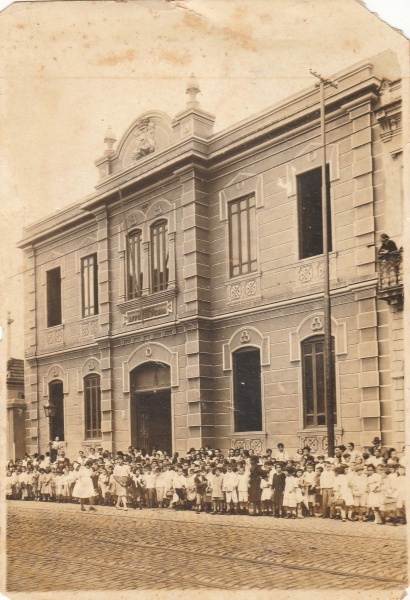 Fotografia: Alunos em frente a fachada da Escola Modelo Affonso Penna. Década de 10. Dimensões 12 X 18 cm. Conservada.