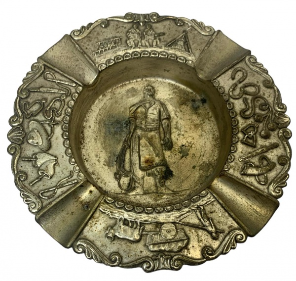 Cinzeiro em alpacca com uma figura de um gaúcho ao centro. medida: 14cm