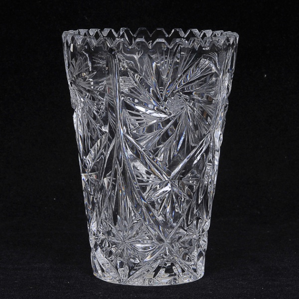 Vaso floreira em cristal europeu ricamente lapidado com palmas, geométricos e frisos, bordas recortadas e base estrelada. Med: 15 x 11cm