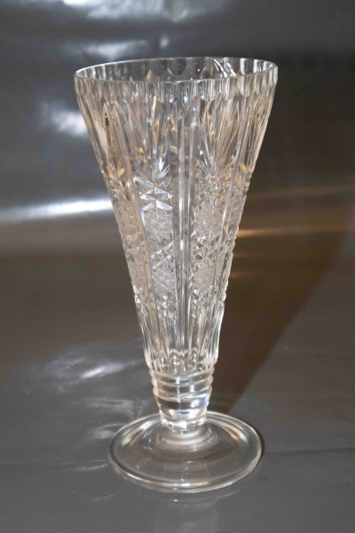 Belíssimo vaso floreira cônico em cristal europeu translúcido, lapidado com palmas e geométricos com a borda canelada. Med: 28cm