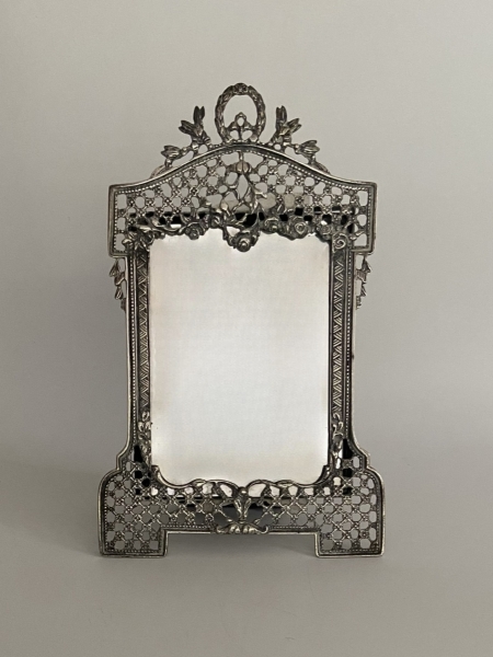 Espelho com moldura em prata teor 830, moldura vazada e decorada com motivos florais. Med: 22 x 12 cm. Peso: 98 g.(somente a moldura).
