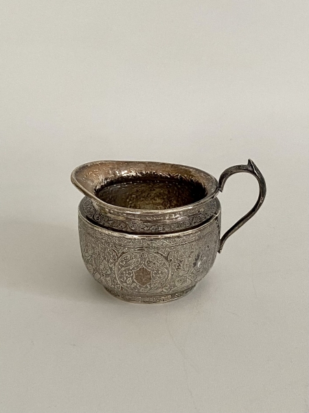 Pequena jarra em prata. Ricamente lavrada com cenas e aves no bojo. Contraste persa. Med: 6 x 7 cm. diam. Peso: 87 g.