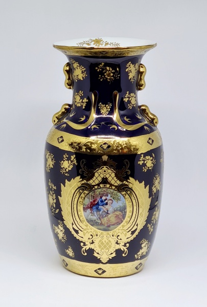 Exuberante vaso em porcelana européia com rica policromia em fundo azul cobalto com reserva em cenas