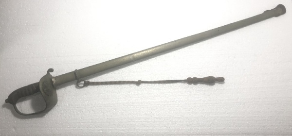 Antiga espada do Exército Brasileiro em metal prateado. Lâmina decorada com florais e inscrição "