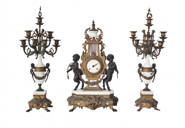 Garniture de lareira em mármore e bronze. Med. 63 x 36 cm (relógio) e 70 x 30 cm (candelabros) .