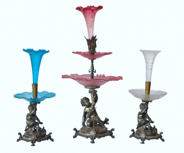 CHRISTOFLE : Excepcional e raro conjunto de três fruteiras para centro de mesa em bronze espessurado a prata da Maison Christofle Paris . Base com Putti com cornucópia apoiados em platô circular com concheados e folhagens , pratos de cristais e vidros opalinados , com alguns defeitos . França circa 1830 . Med. 70 cm alt (maior) e 50 cm alt (menor)