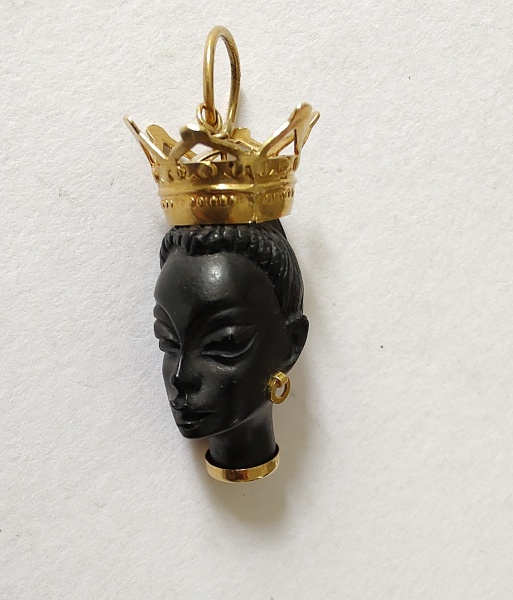 Pingente em coco, cabeça de mulher com coroa e brincos em ouro amarelo 18 k . Peso bruto. 3,5 gr Med. 3 cm