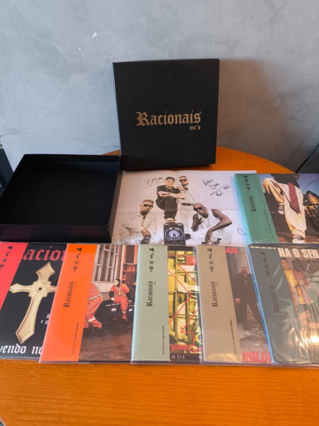 ALERTA RARIDADE Box Racionais COMPLETO AUTOGRAFOS DE TODOS| todos os álbuns do grupo, todos com "obi", todos completos, no total 6 álbuns de carreira que juntos totalizam 10 Lps ( "sobrevivendo no inferno" é duplo e o  "chora agora ri depois" é quádruplo) Acompanha poster autografado a mão por todos integrantes  ||Em excelente estado.| Classificação técnica: capa vg+/ disco vg+ | Verifique nas fotos se acompanha encarte | Verifique com atenção as imagens deste lote e entre em contato conosco até um dia útil antes do leilão, se houver dúvidas. As classificações quanto ao aspecto da capa e do disco são interpretativas com base na apreciação visual. Os discos deste leilão são usados e não são testados, podendo conter ruídos ou estalos.