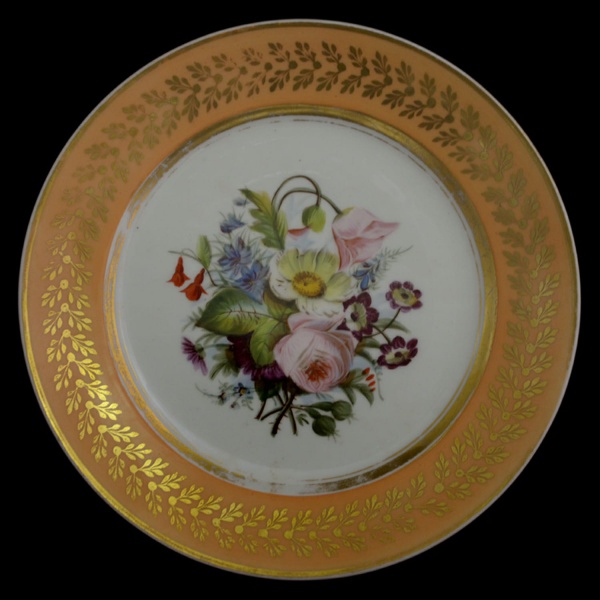 CASA IMPERIAL DO BRASIL. Prato que perteceu à IMPERATRIZ D. LEOPOLDINA, Arquiduquesa d`Austria, primeira esposa de D. Pedro I. Porcelana francesa, borda alaranjada e carcadura de flores douradas, decoração floral ao centro. Datado 1817-1818. Med. 22 cm.