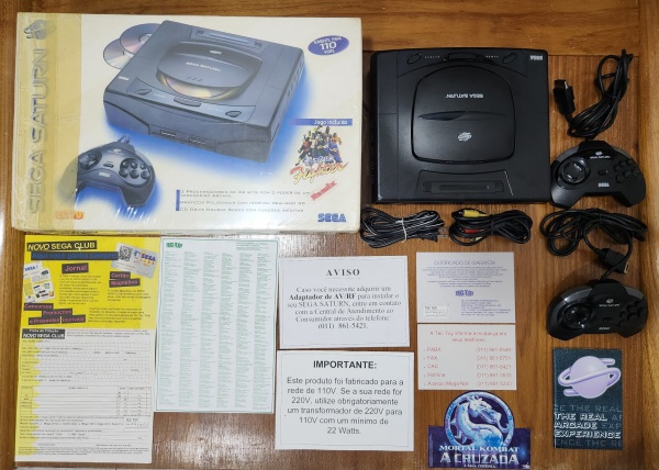 RARO Vídeo Game Sega Saturn da primeira edição lançada no Brasil na caixa, com todos os manuais, Panfletos, carta resposta e folders, essa edição vinha com 2 duas manetes / controle que estão impecáveis, assim como o console cabos, tudo impecável. Em excelente estado, original e funcionando! Para colecionadores exigentes!