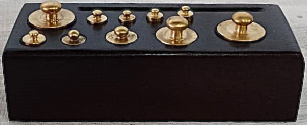 Conjunto de pequenos pesos para balança, em bronze. Dimensões da caixa: 13 cm de comprimento e 5,5 cm de largura.