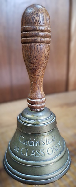 Antiga sineta escolar de bronze, com inscrições. 16,5cm de altura. 8 cm de diâmetro.