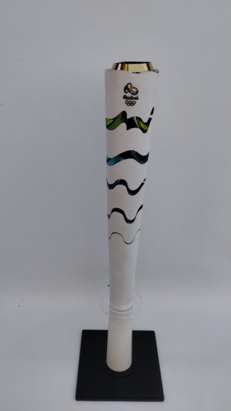 Tocha olimpica 2016. o comprimento da tocha quando fechada é de 63,5 cm e quando expandida é de 69 cm. ela pesa aproximadamente 1,5 kg. ele foi produzida com alumínio reciclado, resina e acabamento acetinado, acompanha base em acrilico, peça em perfeito estado.