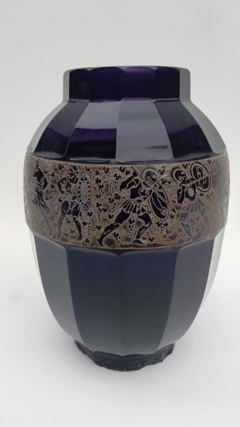 Lindissimo vaso em vidro moser de ametista na cor violeta, peças foram fabricadas entre 1911-1938 com congelamento dourado na parte exterior representando guerreiros tribais com relevos, peça pelo fato do tempo apresenta alguns bicados na base como podem ser vistos nas fotos, e tambem na parte da boca, porem nada ofusca a beleza da peça. medidas 25cm alt x 55cm de circunferencia na parte do meio