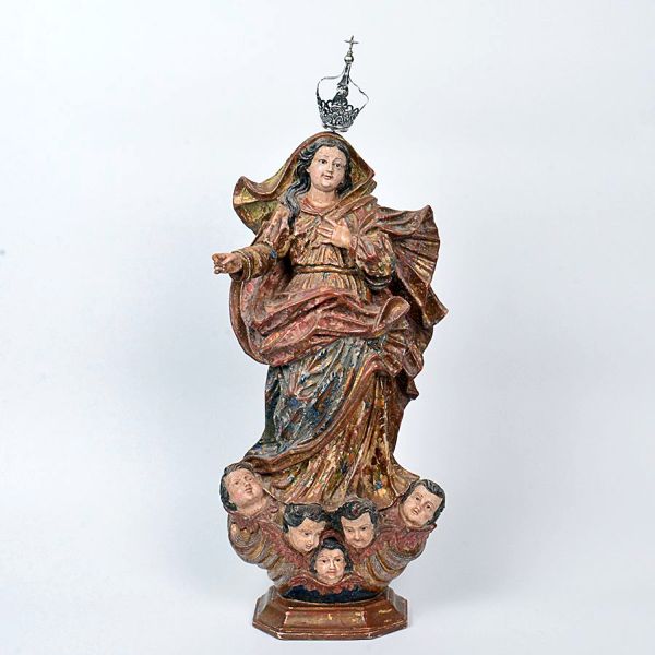 Bela imagem de <b>Nossa Senhora da Conceição </b>em madeira policromada com vestes entalhadas em diversas direções conferindo seu belo movimento. Base chanfrada esculpida com cinco cabeças de anjos entre volutas. Coroa em prata. Séc. XVIII. Alt. 58 cm