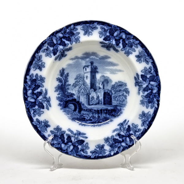 W. T. Copeland & Sons, Inglaterra, 1848. Elegante e raro prato fundo em porcelana decorada no padrão dito Ruins ou Melrose. Fabricação no dia 15 de setembro de 1848, segundo "marca diamante" constante no fundo, emitida pelo British Patent Office, órgão oficial inglês responsável pelo registro de patentes. Diâmetro = 26 cm. Em ótimo estado de conservação, dada a idade. Leia mais: A W. T. Copeland & Sons foi uma importante empresa de cerâmica britânica fundada no início do século XIX. Originou-se da parceria entre Josiah Spode II e William Taylor Copeland. Após a morte de Spode em 1827, Copeland assumiu a empresa, que a partir de 1847 passou a se denominar oficialmente W. T. Copeland & Sons. Sediada em Stoke-on-Trent, Inglaterra, a empresa era reconhecida pela produção de cerâmica e porcelana de alta qualidade. A cerâmica Copeland deu continuidade à tradição Spode de produzir peças ricamente detalhadas e decoradas, incluindo utensílios de mesa, peças ornamentais e azulejos. A empresa permaneceu como um ator significativo na indústria cerâmica britânica até o século XX, retornando ao nome Spode a partir da década de 1970.