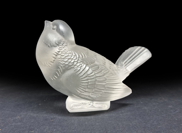 René Lalique (1860-1945). MOINEAU MOQUEUR / PARDAL ZOMBETEIRO. 1930 C. Peso de papel em vidro fosco, modelo 1167. 11 x 9 x 6 cm. Assinado R. Lalique. Pequenino bicado na base, indetectável quando a peça se encontra em sua posição natural. Pertenceu à Coleção Lourdes Catão.