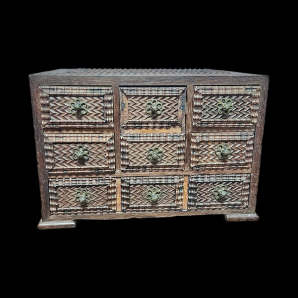 Pequeno móvel gaveteiro entalhado em madeira nobre, a gaveta superior central falta 2 pequenas ripas conforme foto. Medidas.: 23 x 33 x 23cm.