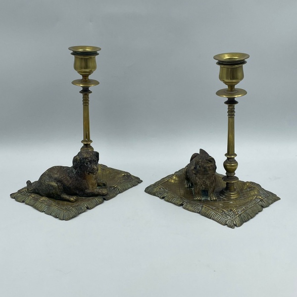 FRANZ BERGMANN GESCHUTZT - Antigo par de castiçais em bronze austríaco, um com representação de um gato, o outro com a de um cachorro. Apresenta marcação do fabricante na base conforme foto adicional. Medidas: 15 x 18cm