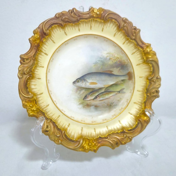 ROYAL DOULTON - DOULTON BURSLEM ENGLAND - MANUFACTURED FOR 175 OXFORD ST. PHILLIPS LONDON - Prato em cerâmica inglesa, decorado com volutas douradas nas bordas, ostentando a imagem de um cardume no centro, na parte trás apresenta marcação da manufatura Inglesa conforme fotos adicionais. Em excelente estado. Medidas.: 23,5cm.