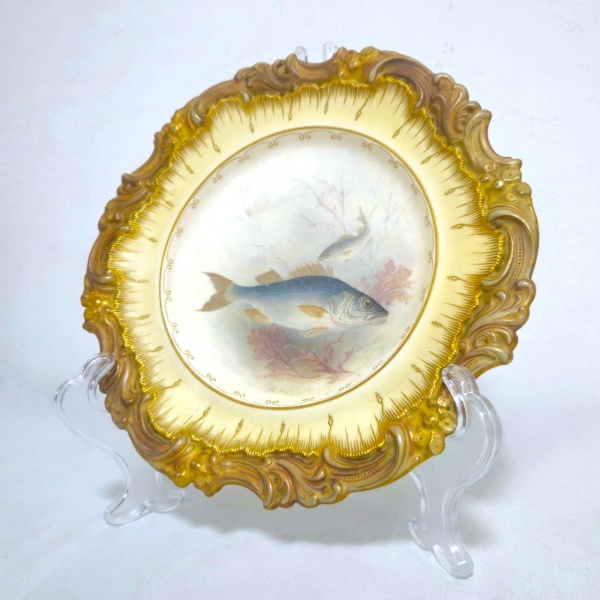 ROYAL DOULTON - DOULTON BURSLEM ENGLAND - MANUFACTURED FOR 175 OXFORD ST. PHILLIPS LONDON - Prato em cerâmica inglesa, decorado com volutas douradas nas bordas, ostentando a imagem de um cardume no centro, na parte trás apresenta marcação da manufatura Inglesa conforme fotos adicionais. Em excelente estado. Medidas.: 23,5cm.