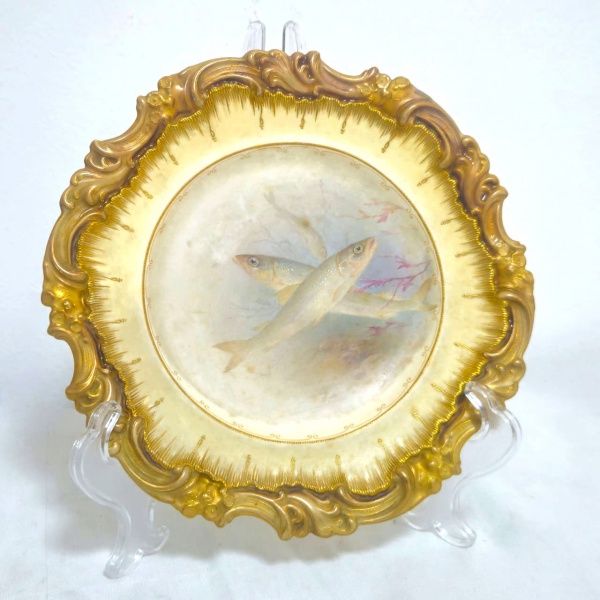 ROYAL DOULTON - DOULTON BURSLEM ENGLAND - MANUFACTURED FOR 175 OXFORD ST. PHILLIPS LONDON - Prato em cerâmica inglesa, decorado com volutas douradas nas bordas, ostentando a imagem de um cardume no centro, na parte trás apresenta marcação da manufatura Inglesa conforme fotos adicionais. Em excelente estado. Medidas.: 23,5cm.