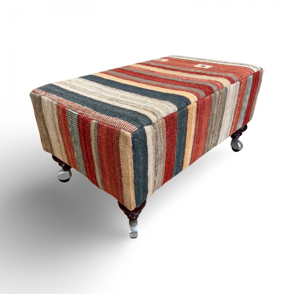 Belíssimo banco com design clássico executado pela oficina inglesa no formato retangular com revestimento artesanal em tapete kilim listrado com pés entalhados em madeira com rodízios. Perfeito estado de conservação