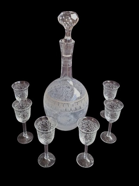 Licoreira em cristal, acompanhada de 6 taças adornada ricamente por lapidação fina e elegante. Garrafa apresenta mofo e bicado na borda.