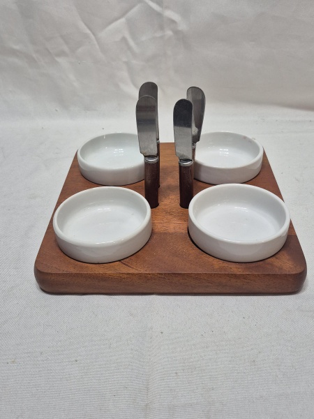 Jogo de 4 petisqueiras em porcelana com suporte em madeira e 4 espátulas de pasta em aço inox. Medindo 22cm x 22cm.