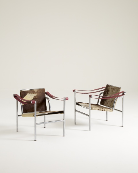 Charlotte Perriand, Le Corbusier e Pierre Jeanneret1887 - 1965) - Probjeto - Par de Poltronas LC1. Aço tubular e pele de vaca. França, 1929. Produzida no Brasil, ca. 1972. Apresenta selo de fabricação e gravação na estrutura de metal. Dimensões: 66 x 60 x 65 cm. Obs.: apresenta desgaste natural na tapeçaria em pele e couro; estrutura de metal em ótima condição.