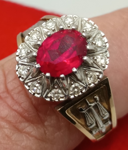 ANEL DE FORMATURA EM OURO 18K, COM RUBI SINTÉTICO, 12 BRILHANTES DE 2 PONTOS CADA PEDRA, 11,1 GRAMAS, MEDIDA ANELAR 25