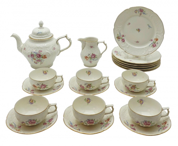 ROSENTHAL SELB-GERMANY SANSOUSSI - Parte de serviço de chá com 20 itens, sendo: 01 bule, 01 leiteira, 06 xícaras de chá, 06 pires para xícaras de chá e 06 pratos de sobremesa; moldados com elementos florais, vegetalistas e volutas em relevo, e decorados com filetes dourados e coloridos motivos florais em suas galerias centrais, tampas e parte interna das xícaras. Numerados na base. Em porcelana da tradicional manufatura alemã Rosenthal, fundada em 1879. Medidas: 25 x 20 cm; 12 x 4 cm.