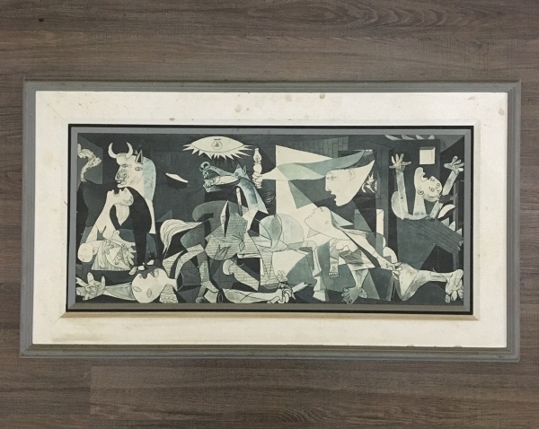 Antiga reprodução "Guernica" de Pablo Picasso em papel texturizado fixado em chapa eucatex, emoldurada. Presença de sinais do tempo na moldura. Dimensões: 48 cm x 85 cm.
