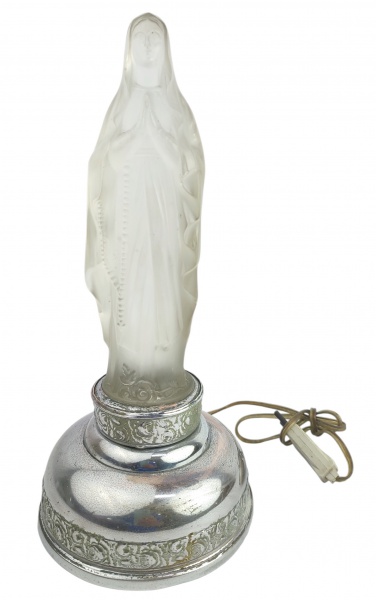 Luminária de mesa em vidro foscado, representando "Nossa Senhora". Base em metal com trabalhos florais em relevo, tendo esta desgastes causados pelo tempo. Funcionando. Alt. 28cm.