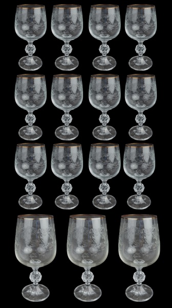 Quinze taças em cristal europeu, decoradas com lapidações em folhagens, sendo 3 para vinho tinto e 12 para vinho branco. Detalhes em dourado com desgastes. Alts. 17cm e 15cm.