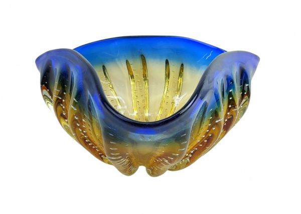Centro de mesa em Murano italiano, nas tonalidades azul e âmbar, trabalhado com gomos em relevo e decorado internamente com bolhas de ar. Apresenta batidas internas. Med. 16x33x35cm.