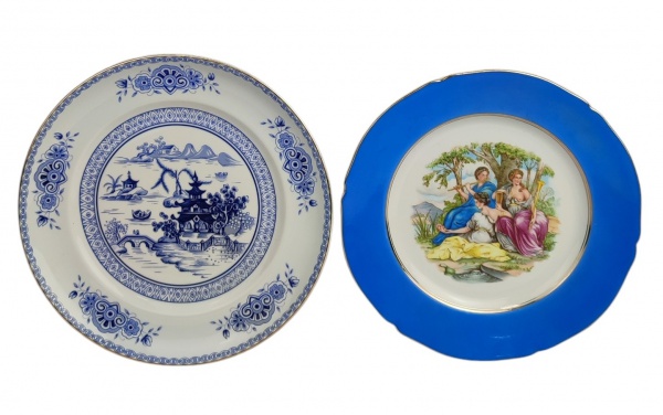 Dois pratos em porcelana portuguesa, sendo um da manufatura Vista Alegre, decorado com paisagem oriental em tons de azul e o outro manufatura Aveiro, decorado de paisagem no ninfas em policromia. Detalhes em dourado. Diâmts. 26cm e 24,5cm.