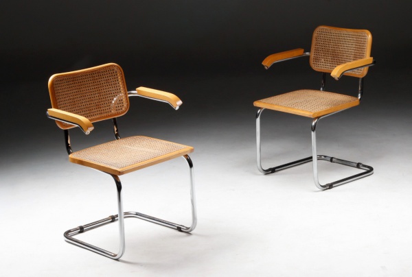 Marcel Breuer - Knoll International - Belo par de cadeiras de braço Cesca em metal tubular cromado com assentos e encostos em madeira nobre maciça e palhinha natural. Apresentam pequenos pontos de oxidação na base. 58x54x82h cm.