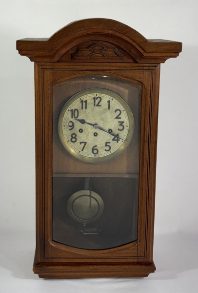 Antigo relógio Alemão carrilhão de parede "Schlagwerk Still". Mecanismo a corda. Caixa em madeira com porta envidraçada. Mostrador em metal. Alt: 74 cm. Larg: 40 cm. (Mecanismo necessitando de reparo).