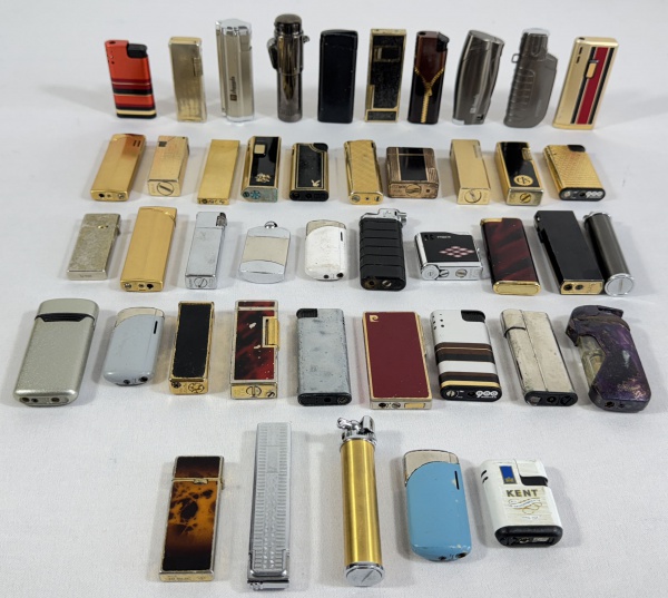 Lote contendo 44 isqueiros de coleção, sendo alguns das marcas "Pierre Cardin, S.T. Dupont, Miniter, Zhengda, Win, Colibri, Hadson, Ibelo, Scorpio, ronson, laser, Peterson's, King, Prince Cute  e Pax Prince. (No estado conforme foto).