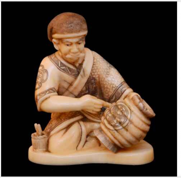 Antiguidades . Netsuke -  CERAMISTA SENTADO SOBRE BASE OBLONGA. Realçado em policromia. ...