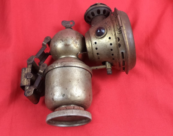 Rara Lanterna de carbureto antiga, também conhecida como lâmpada de acetileno, fabricada pela Joseph Lucas Ltd. em Birmingham, Inglaterra. Modelo "Lucia", frequentemente usada em bicicletas e motocicletas no início do século XX, aproximadamente entre as décadas de 1910 e 1930. Completa, necessita limpeza (apresenta uma trinca no vidro)
