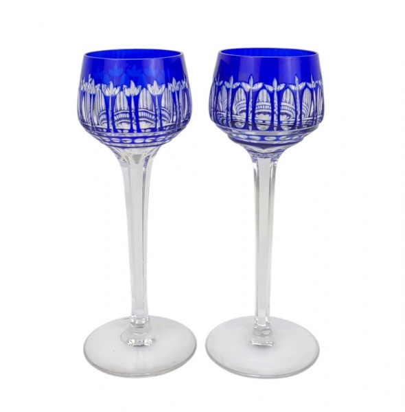Par de taças em cristal europeu, na tonalidade double azul e translúcido, decoradas com lapidações em sulcos e folhagens. Hastes sextavadas. Alt. 20cm.