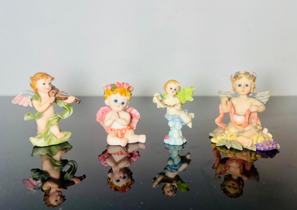 Joias . Lote com 4 bibelôs executados em resina, representando Anjos. Medem 7x2x4cm, ...