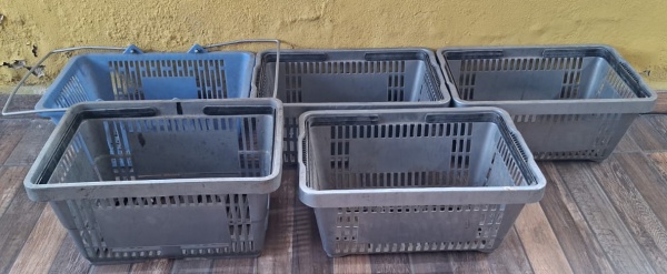 Lote com cinco (5) cestas plásticas de mercado/mercadinho. Elas têm furos nas laterais para ventilação e alças para transporte.