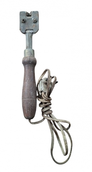 Antiga ferramenta para frisar pneu , usada para reparar e recapear pneus de veículos. Ela possui um cabo de madeira e um fio elétrico, com uma ponta metálica para realizar o corte e a preparação da su