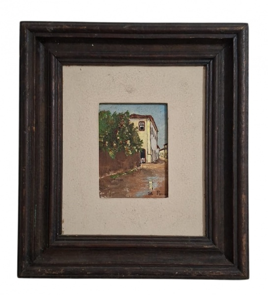 Manuel Pavor, 1988. Casario colonial sem título oficial - - Tema: Rua de cidade histórica brasileira com sobrado, poça d'água refletindo, muro e vegetação - OST - 9cm x 12cm sem moldura - 26cm x 29cm
