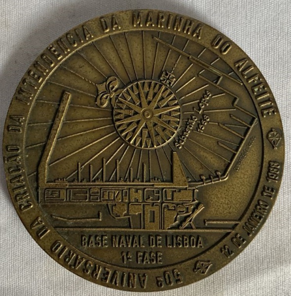 Medalha de bronze da base Naval de Lisboa da Marinha portuguesa na parte central em relevo o brasão no verso em relevo a figura da base Naval de Lisboa primeira fase na borda a inscrição que 50º anive