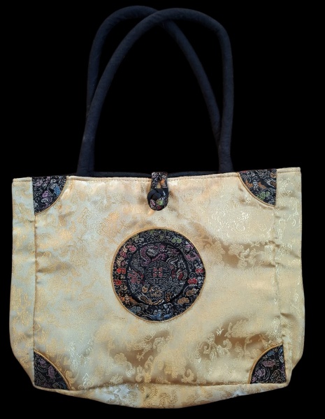 Bolsa Chinesa Tote Seda Brocada com Dragão - Descrição:- Modelo: Tote bag estruturada com alça acolchoada preta- Material: Seda brocada/jacquard dourada/bege + apliques de brocado preto bordado- Detal