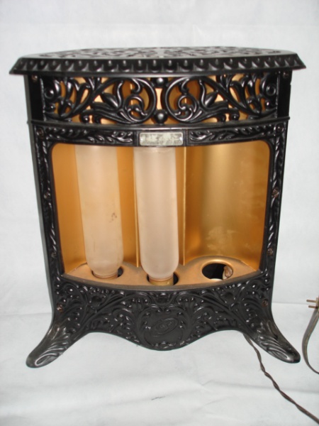 COLECIONISMO - Antigo aquecedor para ambiente, funcionando, falta 1 lâmpada, estrutura de ferro moldado com folhagens e flores, policromia preto fosco com dourado.